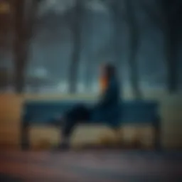 A woman sitting alone on a park bench, looking pensively at the ground, surrounded by empty space, symbolizing her isolation.